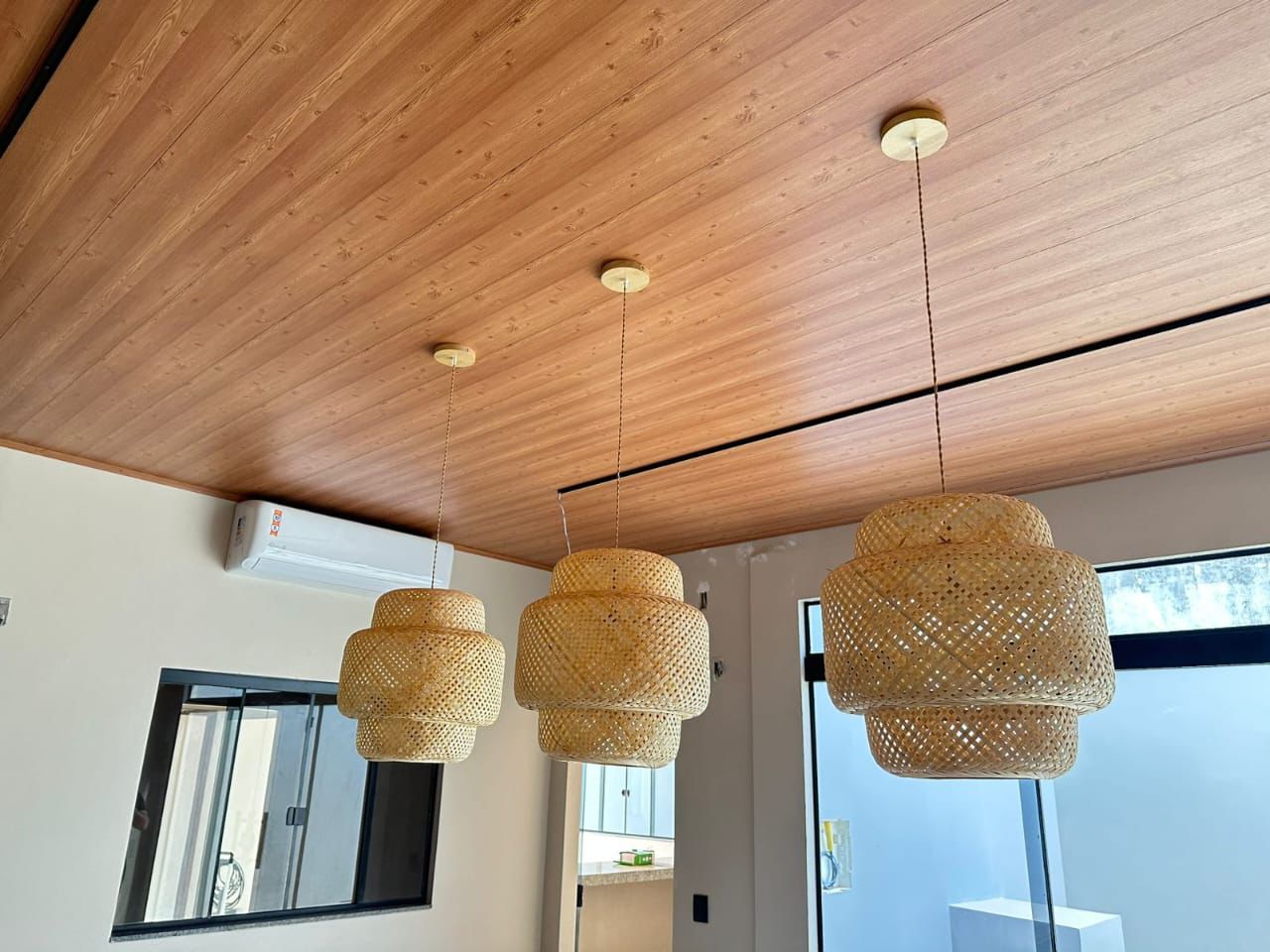 Residência com forro PVC amadeirado e luminárias de fibra natural