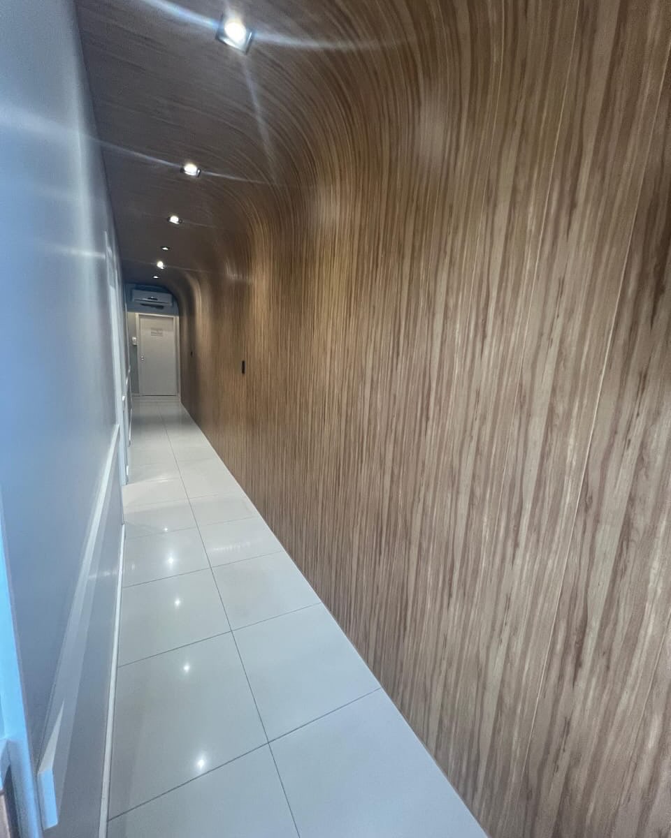 Corredor revestido com forro PVC amadeirado do teto à parede