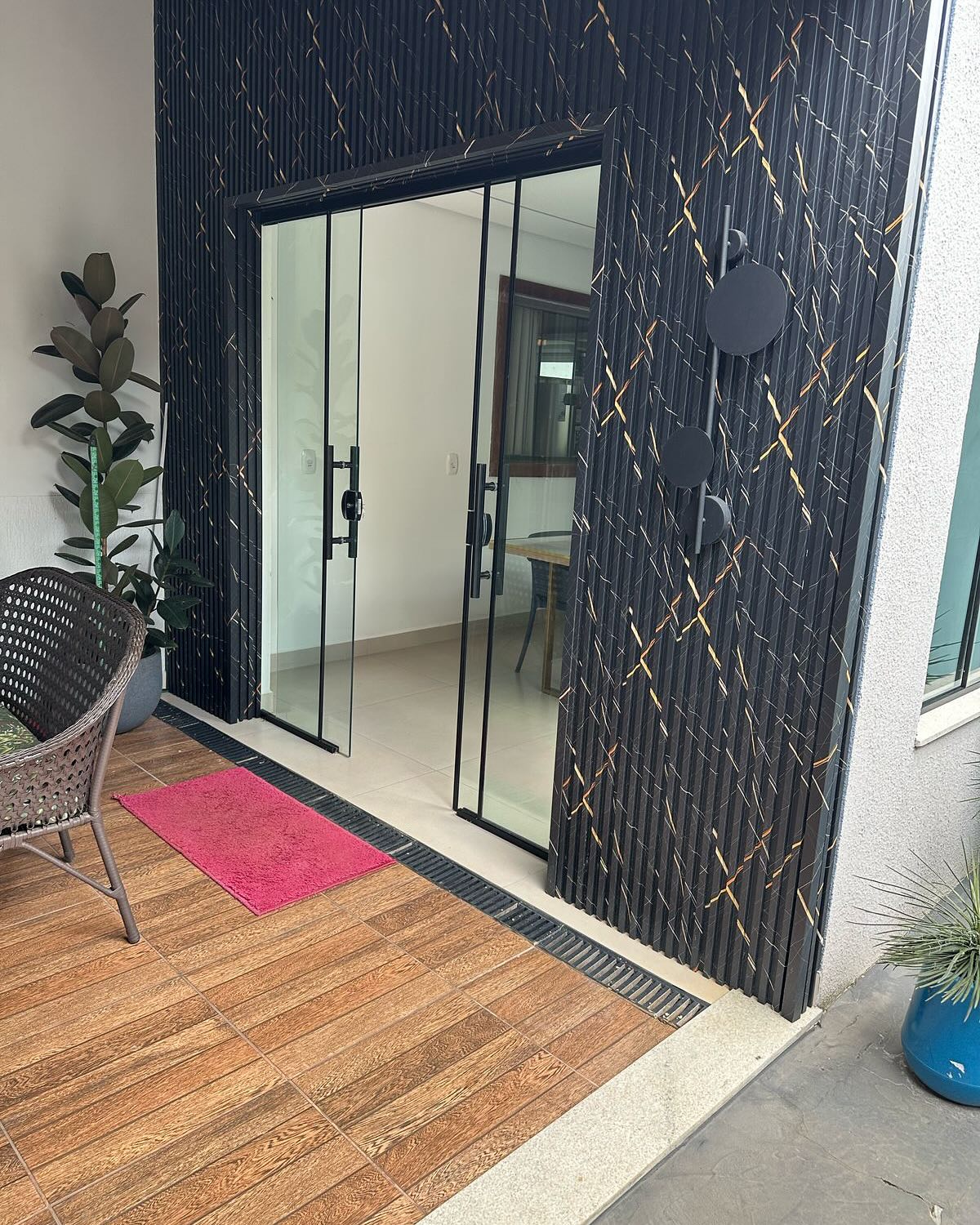 Fachada com painel ripado marmorizado preto e dourado